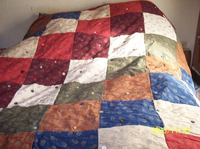 Quilt fashioned from samples of upholstery and buttons.  