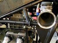 another_shot_of_the_supercharger_under_the_tank_hooked_up_by_a_rubber_grommet_to_the_tube_in_back_of_carb